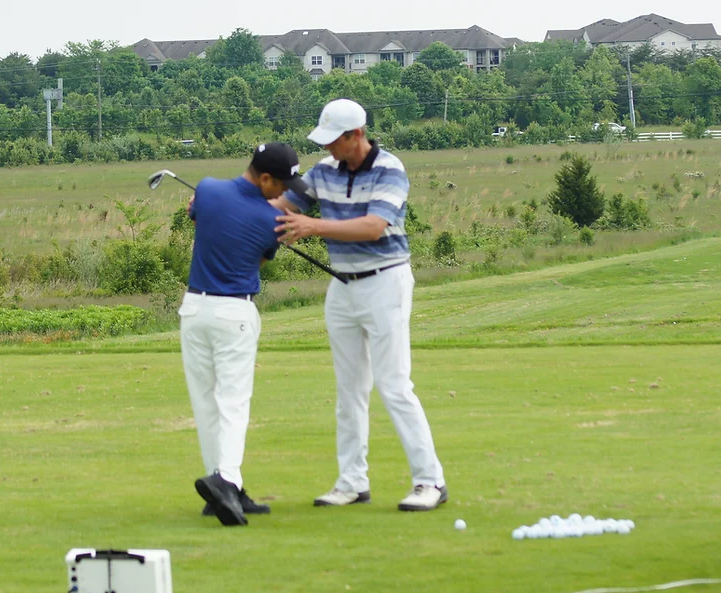 Stephen Moskal teaching a Junior golf student.
